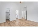 Bright bedroom boasts wood-look flooring, neutral paint, and en suite bathroom access at 5010 Golden Eagle Pkwy, Brighton, CO 80601