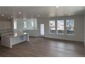 Bright, open-concept living room featuring hardwood floors, recessed lighting, and large windows at 7260 Waterleaf Trl, Littleton, CO 80125