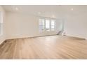 Open living room with wood floors and ample natural light from large windows at 7260 Waterleaf Trl, Littleton, CO 80125