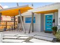 Cozy covered entrance with a table and chairs, modern art and a brightly colored, stylish front door at 822 Poplar St, Denver, CO 80220