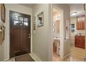 Welcoming entryway featuring a stylish front door, adjacent half bath, and hardwood floors at 3311 S Dahlia St, Denver, CO 80222