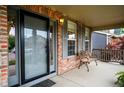 Charming front porch with brick columns, bench, and welcoming entrance at 5774 S Genoa Ct, Aurora, CO 80015