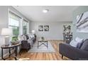 Bright living room featuring hardwood floors, large windows, modern decor, and comfortable seating arrangements for relaxation and entertainment at 6611 Lamar St, Arvada, CO 80003