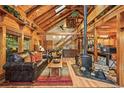 Cozy living room with wood-burning stove, vaulted ceiling, and exposed beams at 1673 Sinton Rd, Evergreen, CO 80439