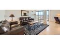 Comfortable living room with hardwood floors, leather sofas, rug, and balcony with city views at 1551 Larimer St # 1402, Denver, CO 80202