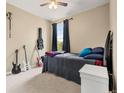 Neutral bedroom offering a ceiling fan, guitars, and a window at 2043 S Cathay Way, Aurora, CO 80013