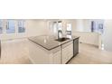 Stylish kitchen island with stainless steel dishwasher, sink and a gray countertop at 7185 Waterleaf Trl, Littleton, CO 80125