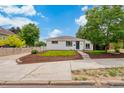 Charming one-story home featuring a well-maintained front lawn, mulch landscaping, and a lovely facade at 1330 Quebec St, Denver, CO 80220