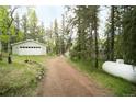 Exterior view of the driveway leading to the house and detached garage at 29055 S Sunset Trl, Conifer, CO 80433