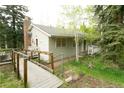 Exterior of the home featuring a brick chimney and wooden walkway at 29055 S Sunset Trl, Conifer, CO 80433