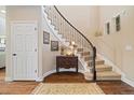Elegant foyer with curved staircase, hardwood floors, and stylish decor at 17452 W 83Rd Pl, Arvada, CO 80007