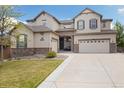 Charming two-story home featuring stone accents, a three-car garage, and a well-maintained front yard at 17452 W 83Rd Pl, Arvada, CO 80007