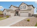 Two-story home with stone accents and a three-car garage, complemented by mature landscaping at 17452 W 83Rd Pl, Arvada, CO 80007