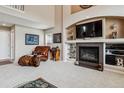 Living room with fireplace, built-in shelves, and leather chair for a cozy, inviting space at 26155 E Euclid Dr, Aurora, CO 80016