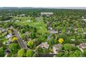 Aerial view of property near a par 3 golf course, surrounded by lush trees and neighborhood streets at 1 Club Ln, Littleton, CO 80123
