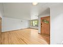 Bright living room featuring beautiful hardwood floors, fresh paint, large windows, and stylish door at 5355 S Windermere St, Littleton, CO 80120