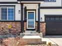 Close up of the home's front door and porch area with brick detail at 2853 Black Canyon Way, Castle Rock, CO 80109