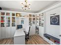 Bright office featuring custom built-in shelving, laminate wood flooring, and a modern chandelier at 2853 Black Canyon Way, Castle Rock, CO 80109