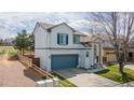An elevated view of a two-story home, featuring a fence, lawn, two-car garage, and vibrant blue shutters at 294 Willowick Cir, Highlands Ranch, CO 80129