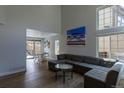 Sunlit living room featuring a large sectional couch, hardwood floors, and an adjacent dining area at 294 Willowick Cir, Highlands Ranch, CO 80129