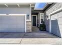 Close up of garage door, front door and stone column and front entry landscape at 5251 Silver Hare Ct, Castle Rock, CO 80104
