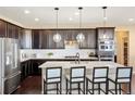 Modern kitchen featuring stainless steel appliances, dark cabinetry, and a large center island at 10055 Fort Worth Ct, Parker, CO 80134