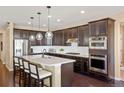 Modern kitchen featuring stainless steel appliances, dark cabinetry, and a large center island at 10055 Fort Worth Ct, Parker, CO 80134