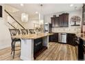 Elegant kitchen with granite island, dark wood cabinets, and stainless steel appliances at 5471 Ensenada Ct, Denver, CO 80249