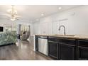 Stylish kitchen featuring granite countertops and stainless steel dishwasher adjacent to an open living area at 14700 E 104Th Ave # 1105, Commerce City, CO 80022