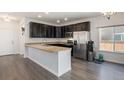 Modern kitchen with dark cabinetry, granite counters, and stainless steel appliances and breakfast bar at 14700 E 104Th Ave # 1105, Commerce City, CO 80022