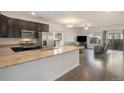 Open-concept kitchen featuring granite countertops and stainless steel appliances flowing into the living area at 14700 E 104Th Ave # 1105, Commerce City, CO 80022
