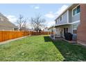 Large, grassy backyard featuring a wooden fence and an outdoor seating area at 12945 E Colorado Ave, Aurora, CO 80012