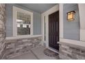 Inviting front entryway with a dark wooden door, stone accents, and a stylish lantern, creating a welcoming atmosphere at 6802 S Uriah St, Aurora, CO 80016