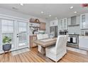 Bright dining area with table, chairs, modern lighting, adjacent to a kitchen with white cabinets at 10042 Hudson St, Thornton, CO 80229