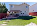 Beautiful backyard featuring a red and white striped awning and a lush green lawn at 10057 Cedaridge Way, Highlands Ranch, CO 80129