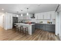 Modern kitchen with white upper cabinets, gray lower cabinets, a large island, and stainless steel appliances at 8767 Chase Dr # 195, Arvada, CO 80003