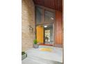 Welcoming entryway with a brightly colored door, brickwork and transom window at 10572 E Orchard Pl, Englewood, CO 80111