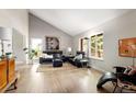 Bright living room featuring large windows, hardwood floors, and vaulted ceiling at 10572 E Orchard Pl, Englewood, CO 80111