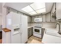 Galley kitchen with white appliances and gray cabinets at 14393 E Marina Dr, Aurora, CO 80014