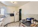 Functional kitchen with classic white cabinets and a table for dining at 2650 W Mississippi Ave, Denver, CO 80219