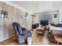 Cozy living room featuring wood floors, a plush recliner, and natural light at 2650 W Mississippi Ave, Denver, CO 80219