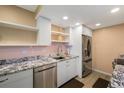 Bright kitchen with stainless steel appliances, granite counters and floating shelves at 3482 S Eagle St # 102, Aurora, CO 80014