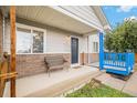 Inviting front porch with a seating area, charming brick accents, and blue railings at 3065 W 80Th Ave, Westminster, CO 80030