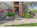 Multi-story home with brick facade, green lawn, landscaped rock feature and manicured bushes at 8422 S Upham Way # G60, Littleton, CO 80128