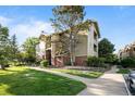 Multi-story home with green lawn, sidewalk, and landscaped flowerbeds with trees at 8422 S Upham Way # G60, Littleton, CO 80128