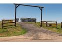 Gated driveway leads to a single-story home under a clear sky at 11809 Pass Me By Rd, Strasburg, CO 80136