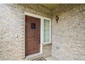 Close-up of a wooden front door showcasing the brick facade and exterior light fixture at 15594 E 97Th Ave, Commerce City, CO 80022