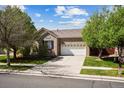 Attractive single-story brick home features a manicured lawn, mature trees, and a driveway at 15594 E 97Th Ave, Commerce City, CO 80022