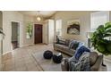 Cozy living room with vaulted ceiling, tile flooring, and stylish neutral decor at 15594 E 97Th Ave, Commerce City, CO 80022