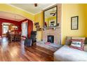 Open-concept living area featuring hardwood floors, a brick fireplace, and bright, contrasting walls at 233 W 3Rd Ave, Denver, CO 80223
